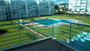 A hotel with multiple white buildings, a swimming pool, and a well-maintained lawn. - Residence Riviera Beach 4112 (Cabo Negro)