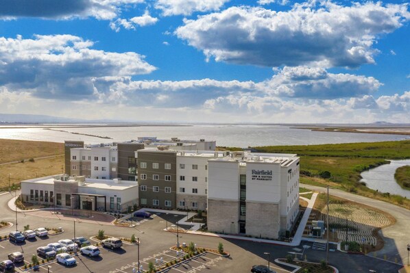 Ein Fairfield Inn & Suites by Marriott Hotel mit Parkplatz und einem Fluss im Hintergrund.