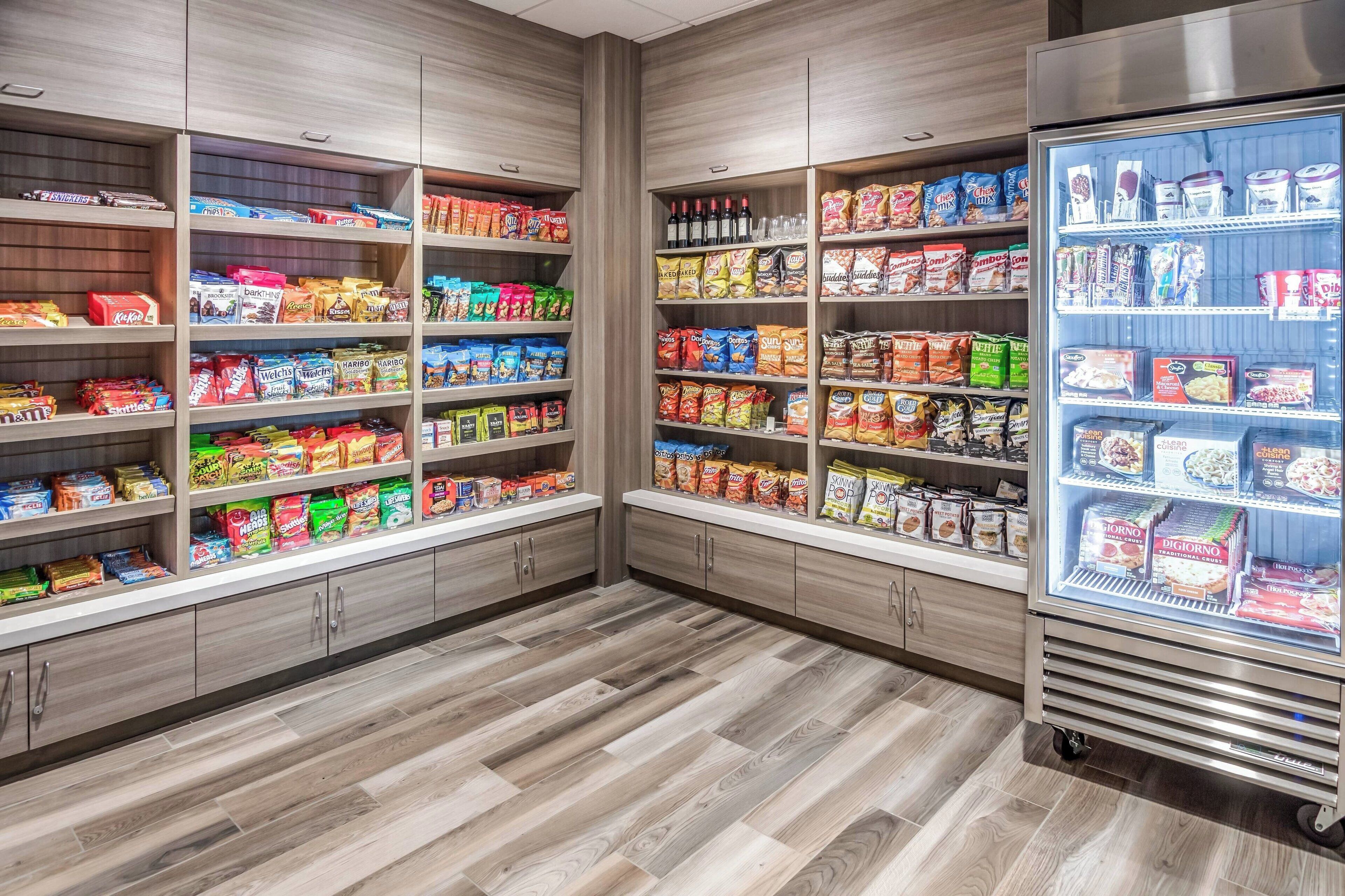 A snack and beverage section with shelves stocked with various snacks and drinks, and a refrigerated display case.