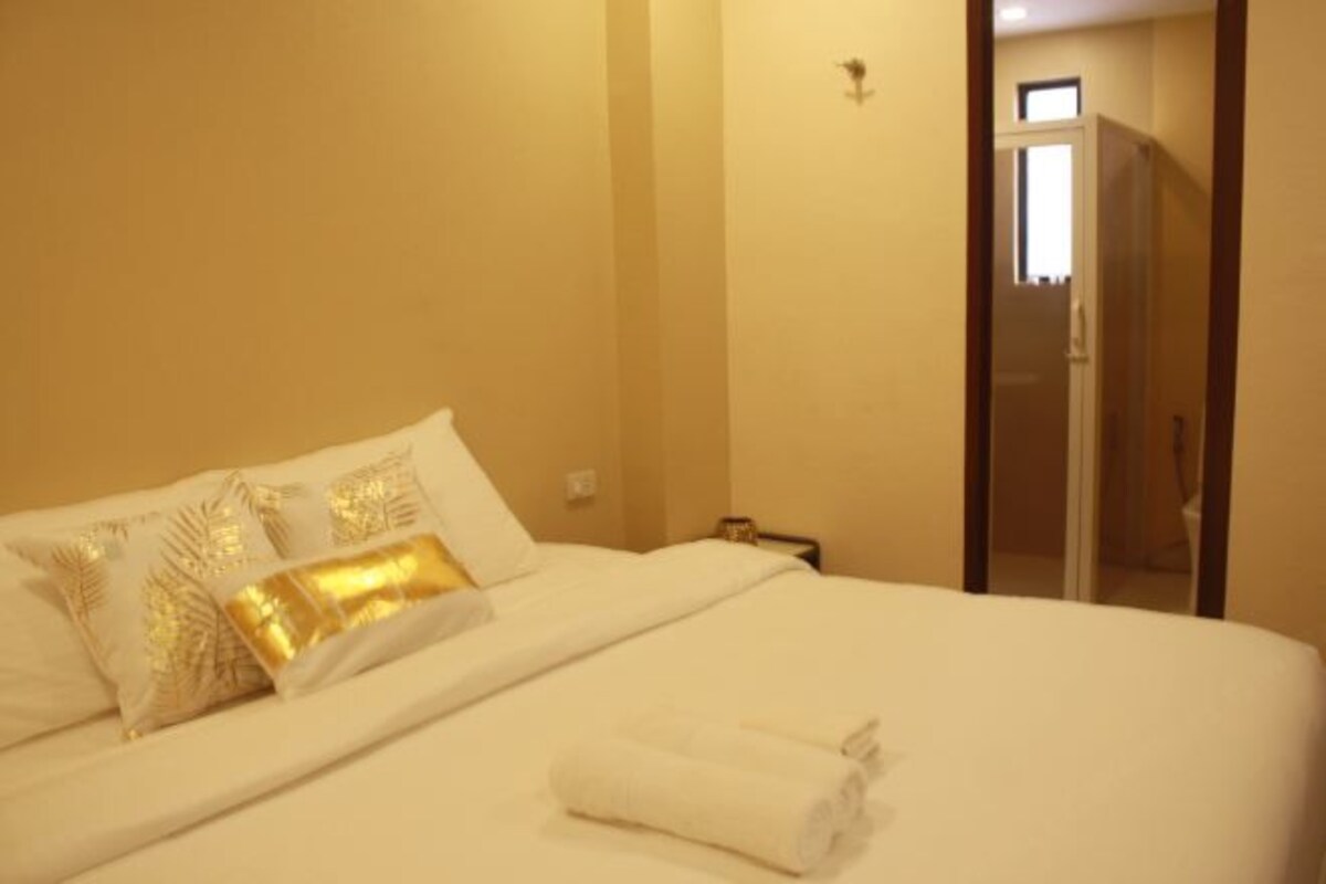 A hotel room with a bed, pillows, and a towel.