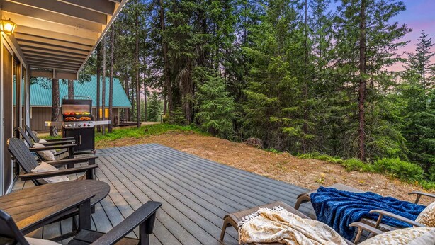 A deck with outdoor furniture, a grill, and a view of a forest. - Sugar Shack - Peaceful and Private Remodeled Cabin (Leavenworth)
