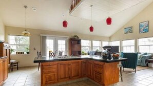 A spacious kitchen with wooden cabinets, a large island, and pendant lights. - Ocean-View 2 Bedroom Home Sleeps 6 Steps From Beach & Train Station, Pets OK (Grover Beach)
