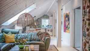 A cozy loft-style living space with a high ceiling, a dining area, and a kitchen.