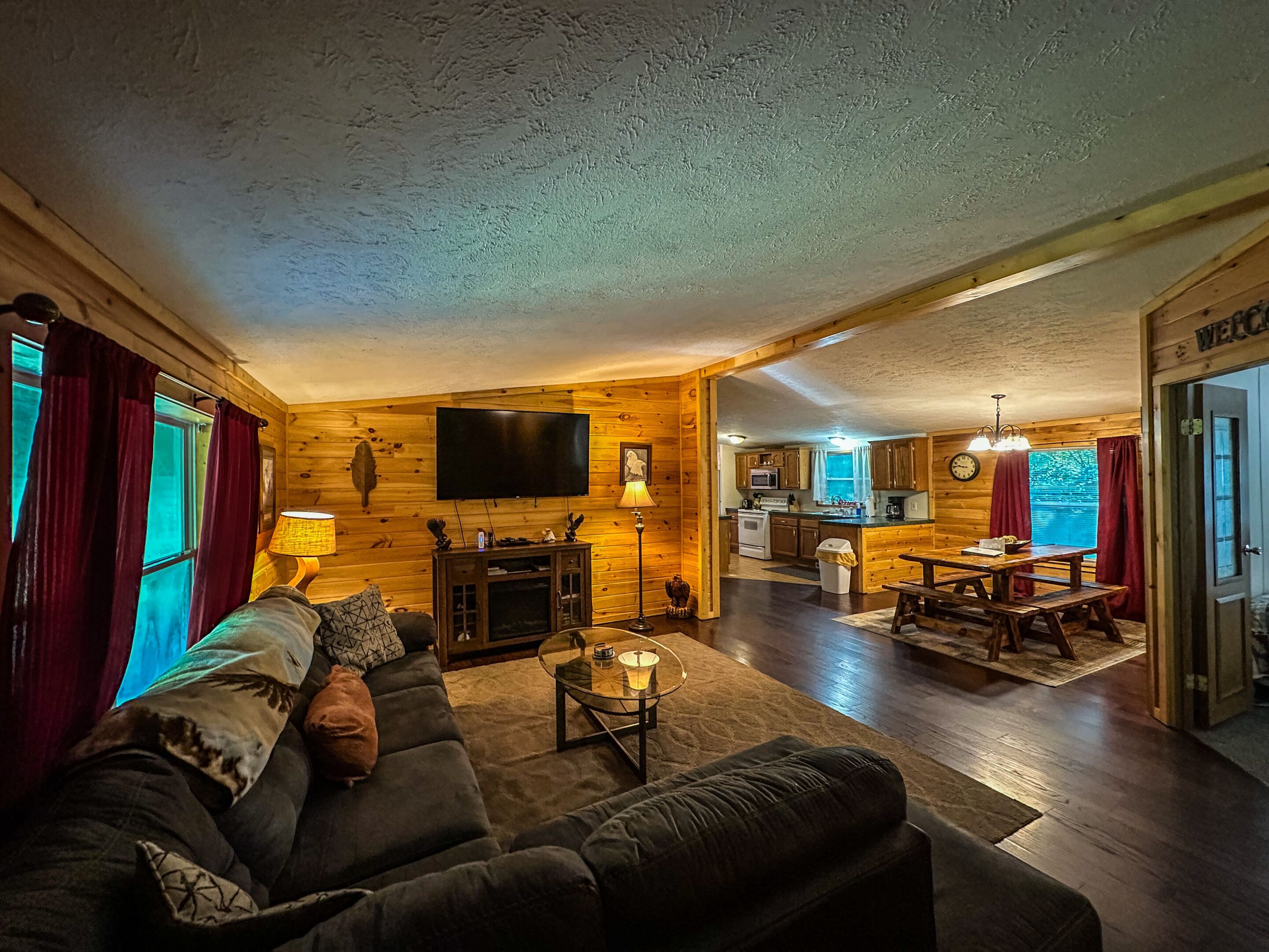 A cozy cabin interior with a living room, dining area, and kitchen.