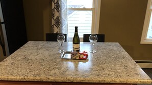 A kitchen counter with a bottle of wine, two glasses, and a tray with food items. - Fabulous studio apartment with roof deck (Portland)