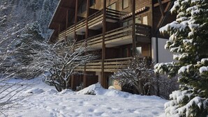 A wooden chalet with a balcony, surrounded by snow-covered trees. - Ammerten A17 by Interhome (Lenk)