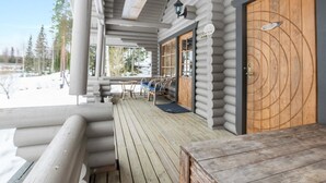 A log cabin with a wooden deck, a covered porch, and a large wooden door. - Kivipirtti by Interhome (Keuruu)