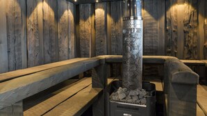 A sauna with wooden benches and a central heating unit. - Kivipirtti by Interhome (Keuruu)