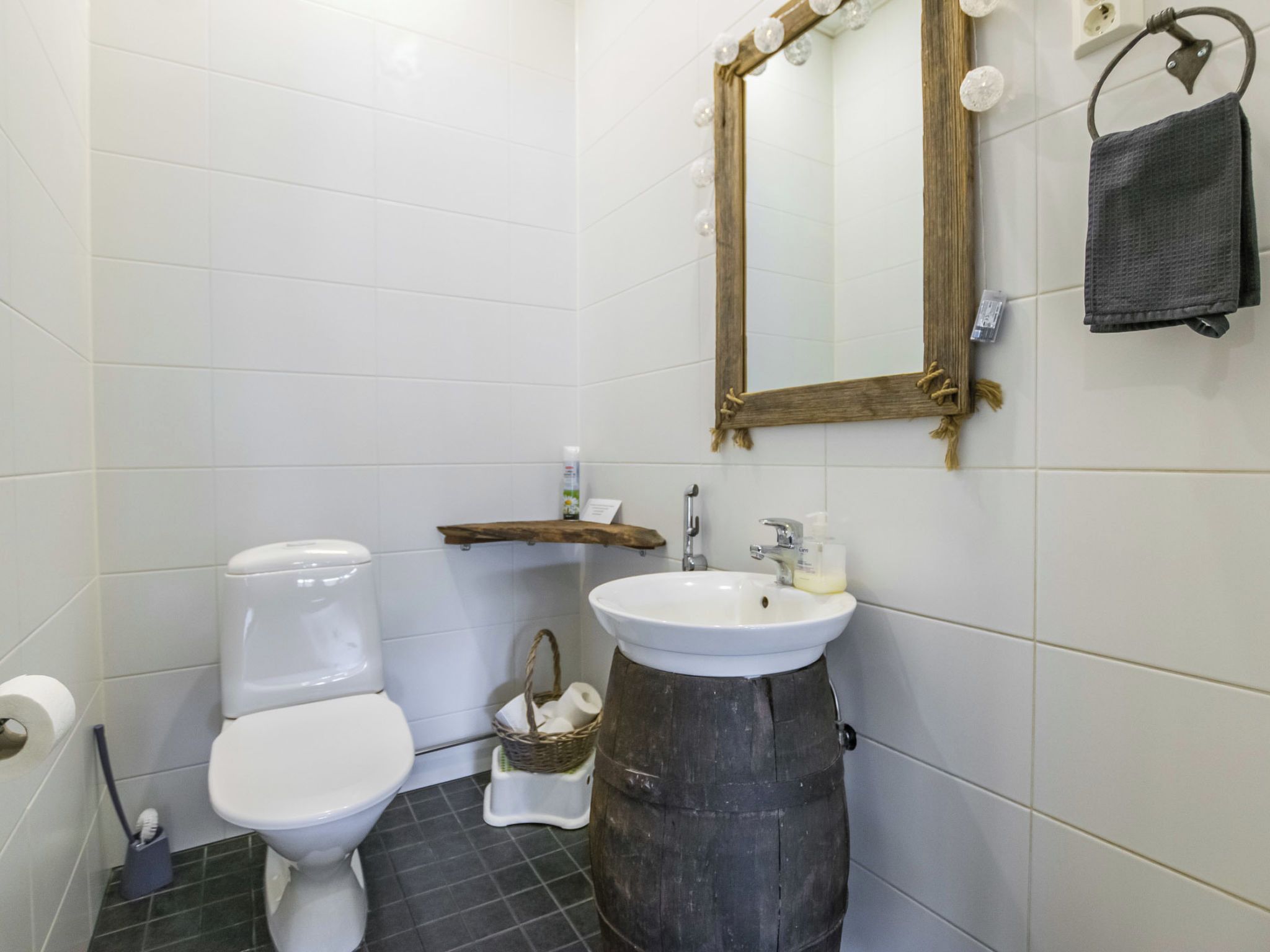 A bathroom with a toilet, sink, and mirror.