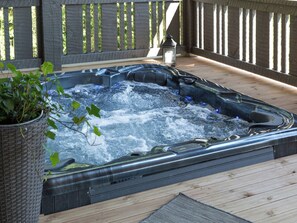 A hot tub on a wooden deck with a potted plant nearby. - Kivipirtti by Interhome (Keuruu)
