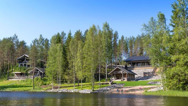 A lakeside lodge with multiple cabins, a large building with a balcony, and a dock extending into the water. - Kivipirtti by Interhome (Keuruu)