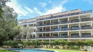 A multi-story hotel with a swimming pool, surrounded by landscaped gardens and trees. - Résidence Cita di Sali by Interhome (Porto Vecchio)