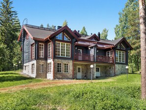 A large, multi-story house with a stone facade, multiple windows, and a balcony. - Syvärinkulta b by Interhome (Nilsiä)