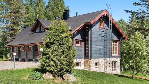 A two-story house with a stone foundation, a dark grey exterior, and red trim. - Syvärinkulta b by Interhome (Nilsiä)