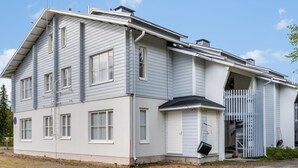 Een gebouw met twee verdiepingen, een garage en een overdekte veranda.