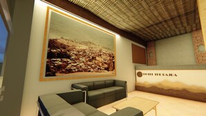 Um lobby de hotel moderno com uma grande pintura emoldurada de paisagem, uma área de estar com sofá e mesa, e uma parede de tijolos com o nome do hotel.