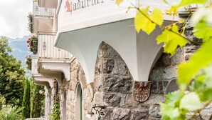 Fachada de hotel con un arco de piedra y un letrero que dice 'Ladurner Hof'.