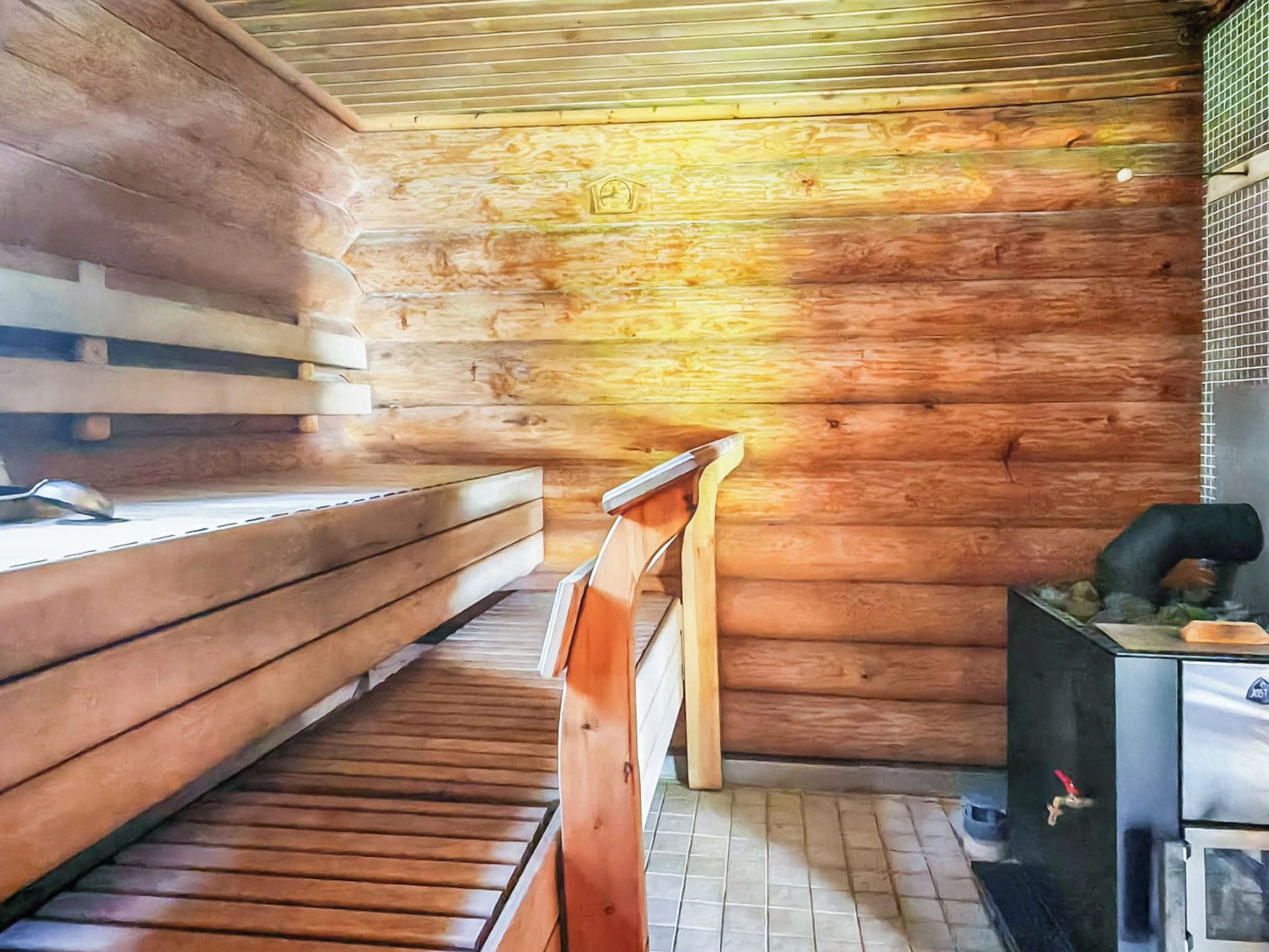 Una sauna con bancos de madera y un banco con respaldo.