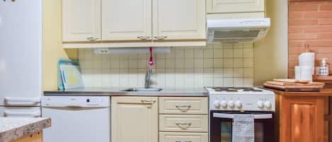 Une cuisine avec des meubles blancs, un lave-vaisselle Bosch, un four Beko et une cuisinière Beko.