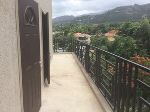 Un balcón con vistas a un paisaje montañoso y casas.