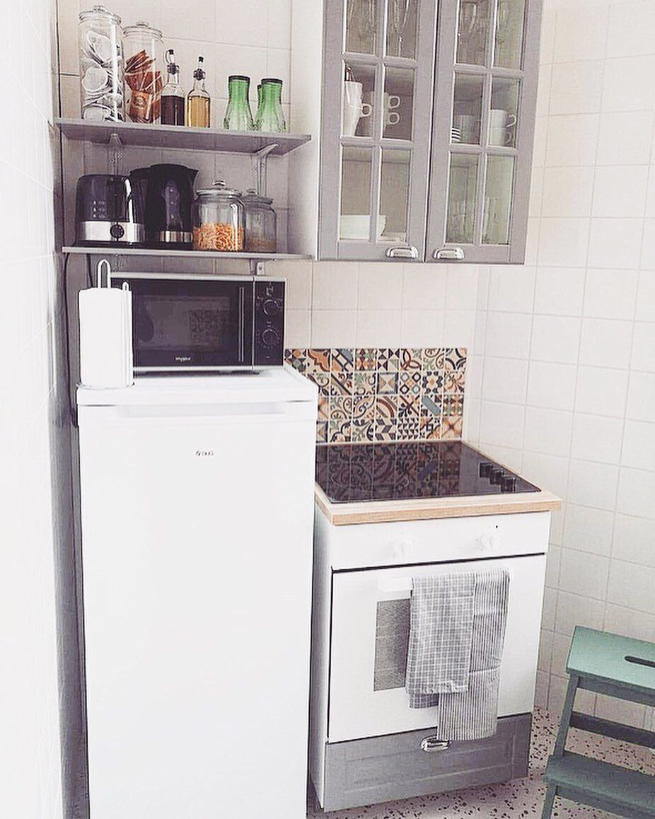 A compact kitchen with a microwave, a stove, and a cabinet above.