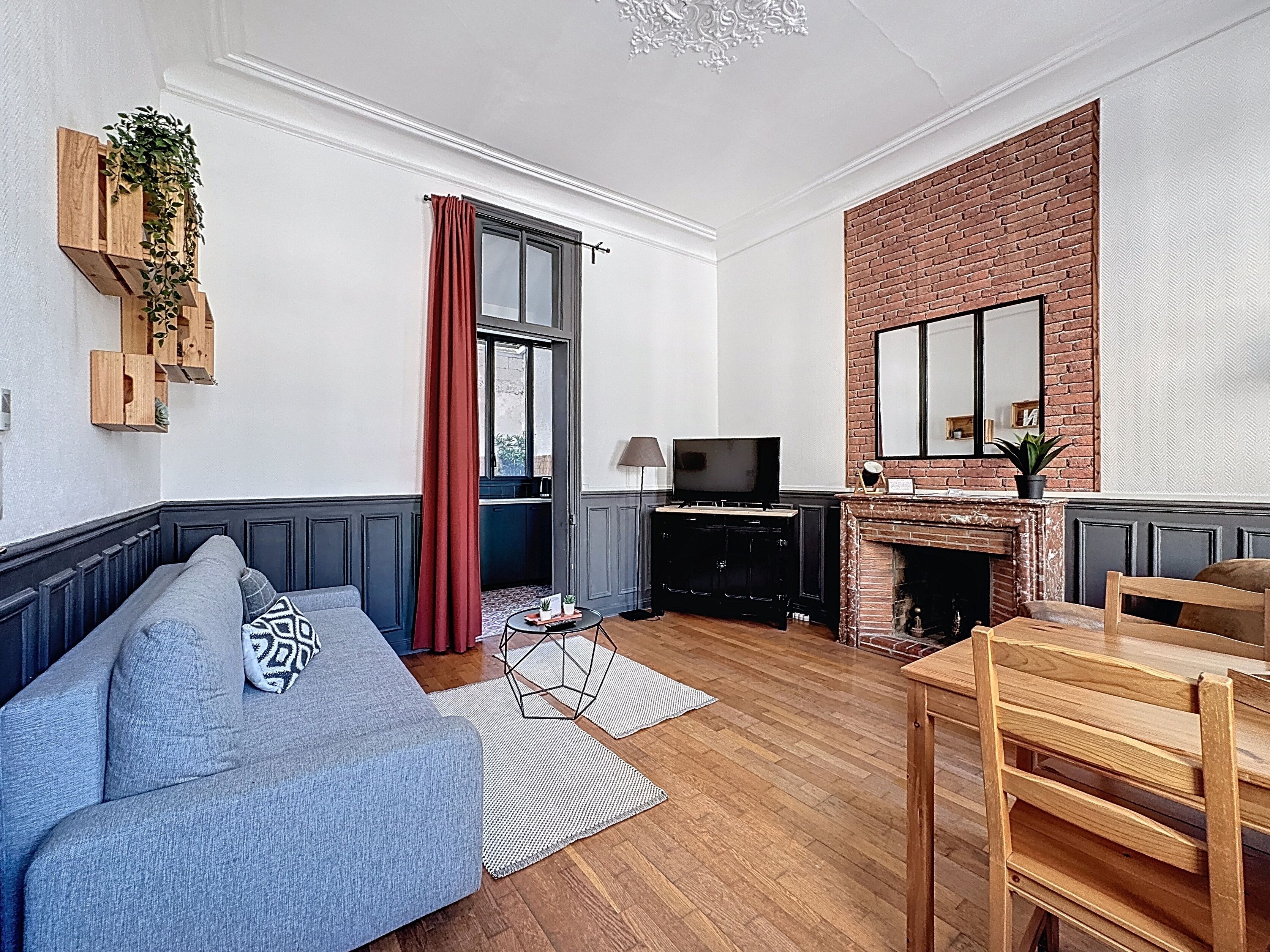 Una sala de estar con sofá, televisor, chimenea y comedor.