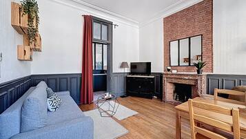 Una sala de estar con sofá, televisor, chimenea y comedor.