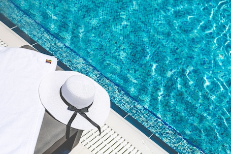 Una piscina al aire libre, camas de piscina gratis, sombrillas