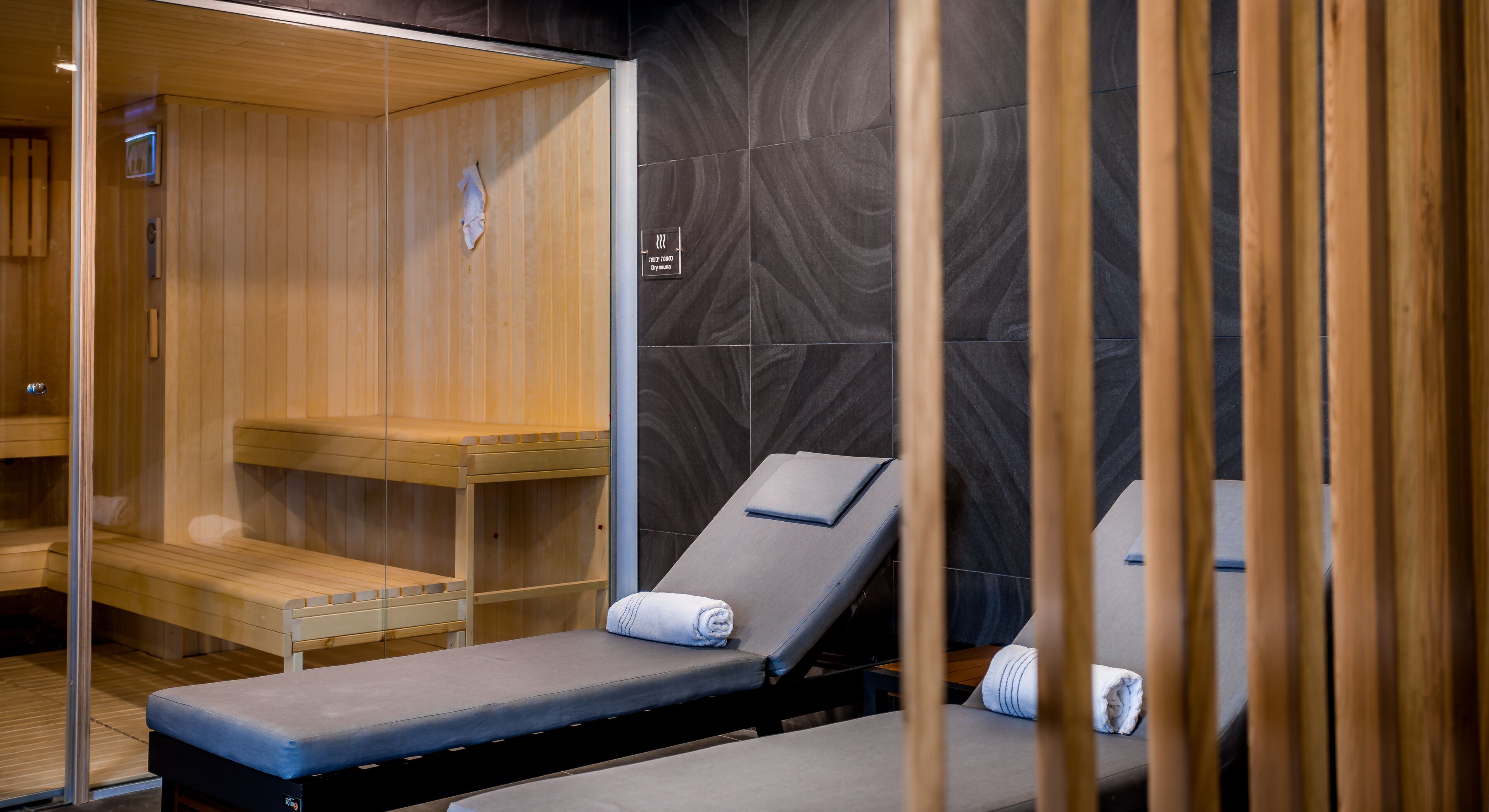 Un cuarto de sauna con bancos de madera y una sola silla reclinable.