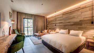 Une chambre d’hôtel moderne dotée d’un grand lit, d’un bureau avec une chaise, d’un canapé et d’une grande fenêtre avec des rideaux.