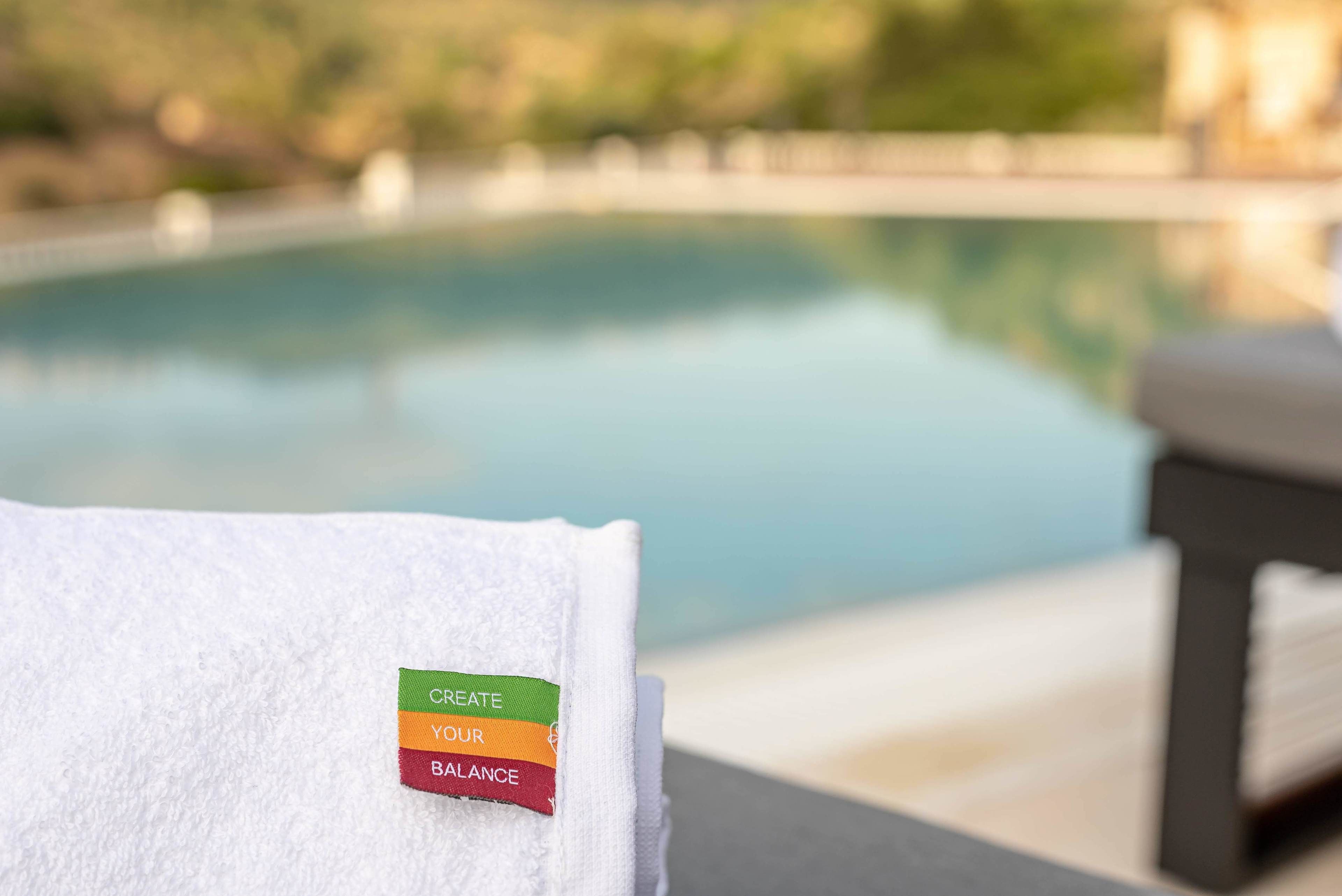 Una toalla con una etiqueta motivacional cerca de una piscina.