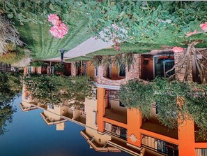 A building with a water feature in front, surrounded by greenery and a pink flower. - Memorable 3 Nights in Napa 1 bd suite-10% (Napa)