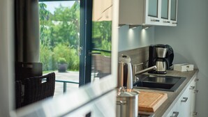 A modern kitchen with a large window, a coffee maker, and a cutting board on the counter. - VILLA EMMA 4A- luxury with sauna, whirlpool, fireplace, view, for 8 pers.+ Babybet (Sellin)