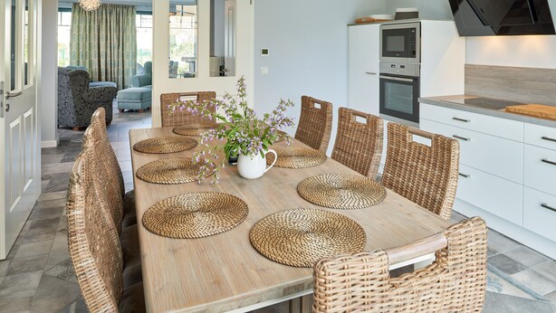 A modern kitchen with white cabinets, a built-in oven, and a microwave.