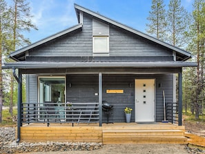 A modern two-story house with a dark exterior, a front porch with a railing, and a door with a small window. - Pallaskieppi by Interhome (Raattama)
