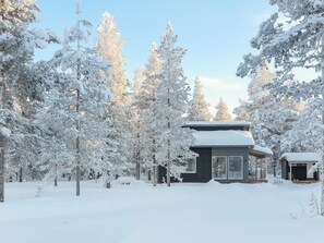 A cabin surrounded by snow-covered trees.