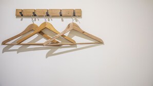 Un perchero de madera con tres perchas de madera.