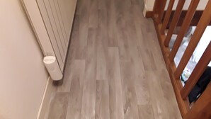 Un suelo de madera con un radiador y una pared blanca.