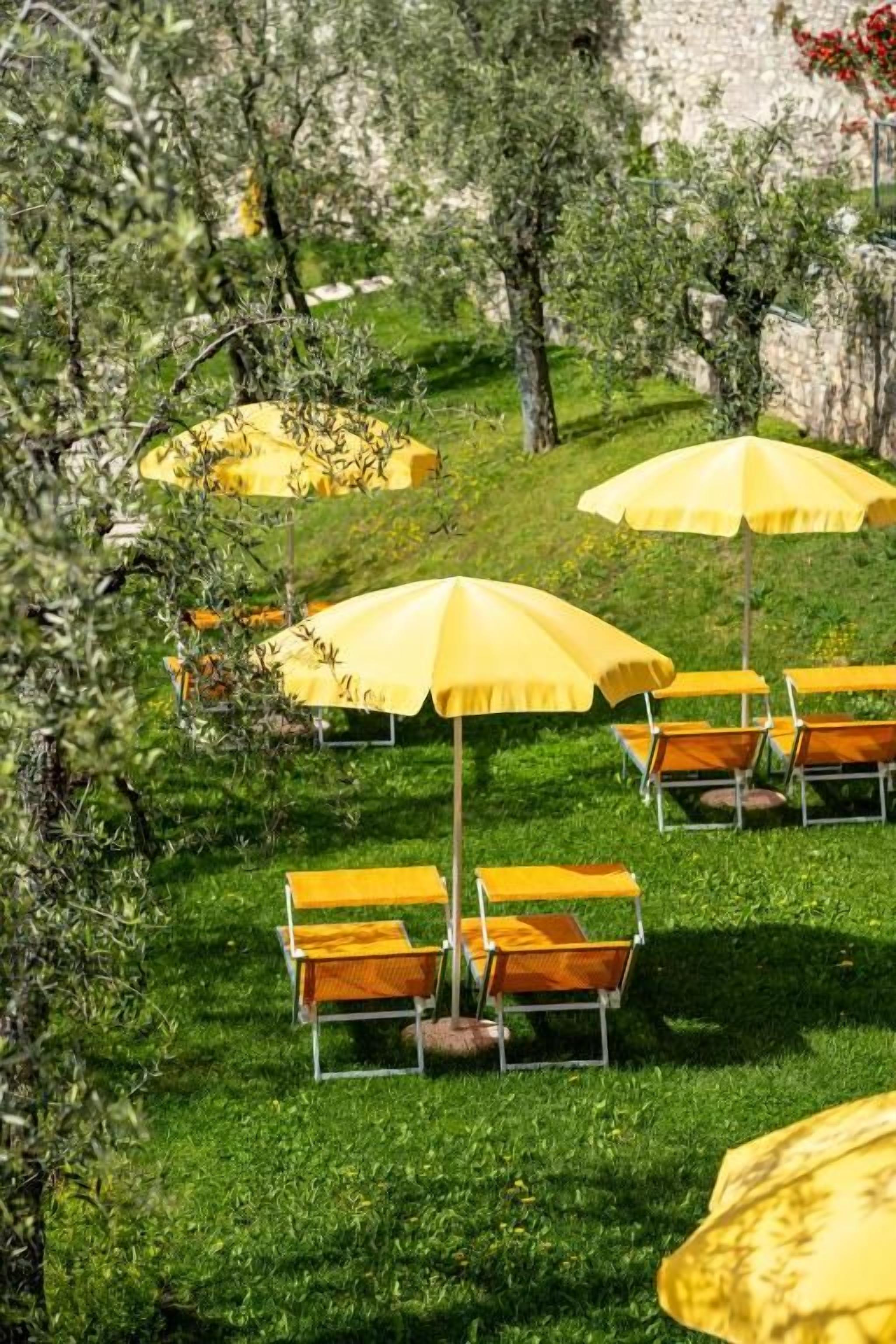 Outdoor seating with yellow umbrellas and wooden benches.