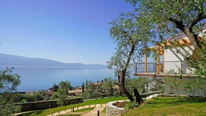 Una propiedad costera con un sendero de piedra que lleva a un edificio con balcón con vistas al mar.