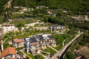 A villa with a garden, solar panels, and a stone wall. - Residence Dany (Gargnano)