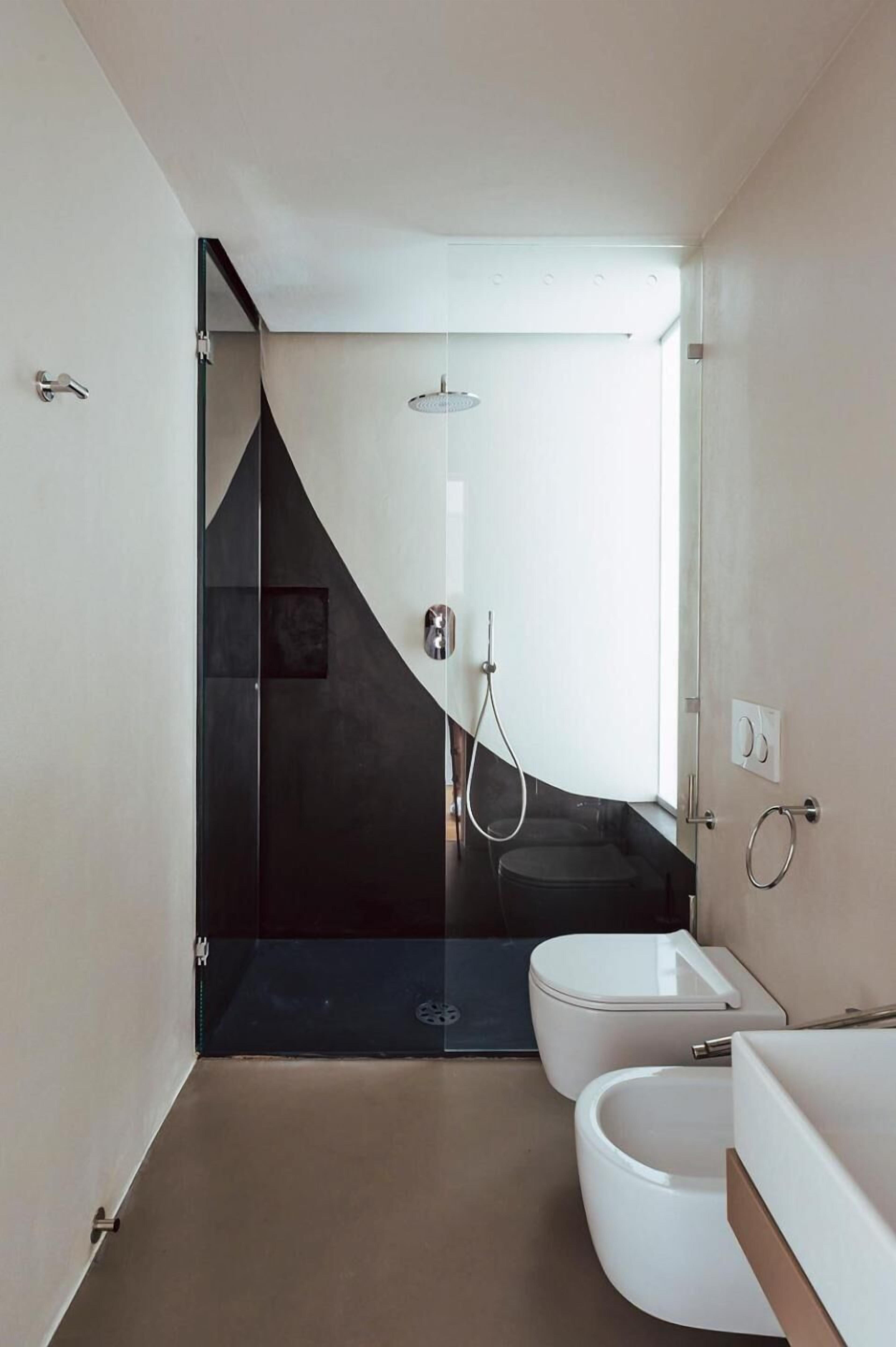 Une salle de bain moderne équipée d’une douche, de toilettes et d’un bidet.