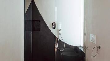 Une salle de bain moderne équipée d’une douche, de toilettes et d’un bidet.