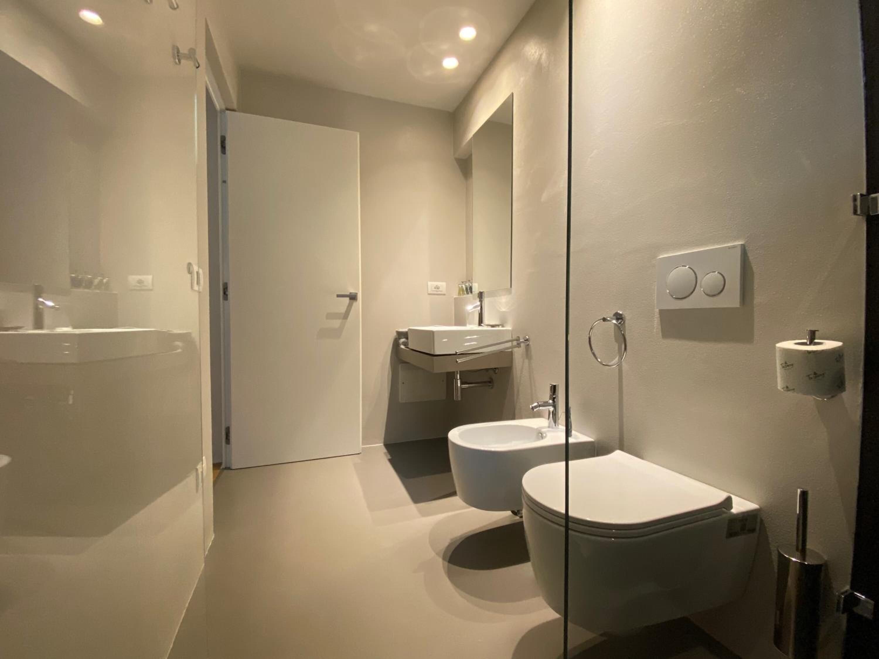 Un baño moderno con inodoro, bidé y lavamanos.