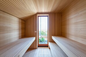 A sauna room with wooden slats on the walls and benches. - Villa Curiel (Castagneto Carducci)