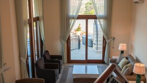 A hotel lobby with a seating area, a staircase, and a view of the outdoor area. - Villa HERMIONA - Wake Up To A Golf View (Paphos)