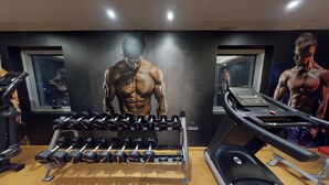 Une salle de sport équipée de matériel d’exercice, notamment des haltères et des tapis de course.