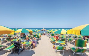 A beach with rows of sun loungers and umbrellas, a clear sky, and the ocean in the background. - Beautiful apartment in Alba Adriatica with outdoor swimming pool (Alba Adriatica)