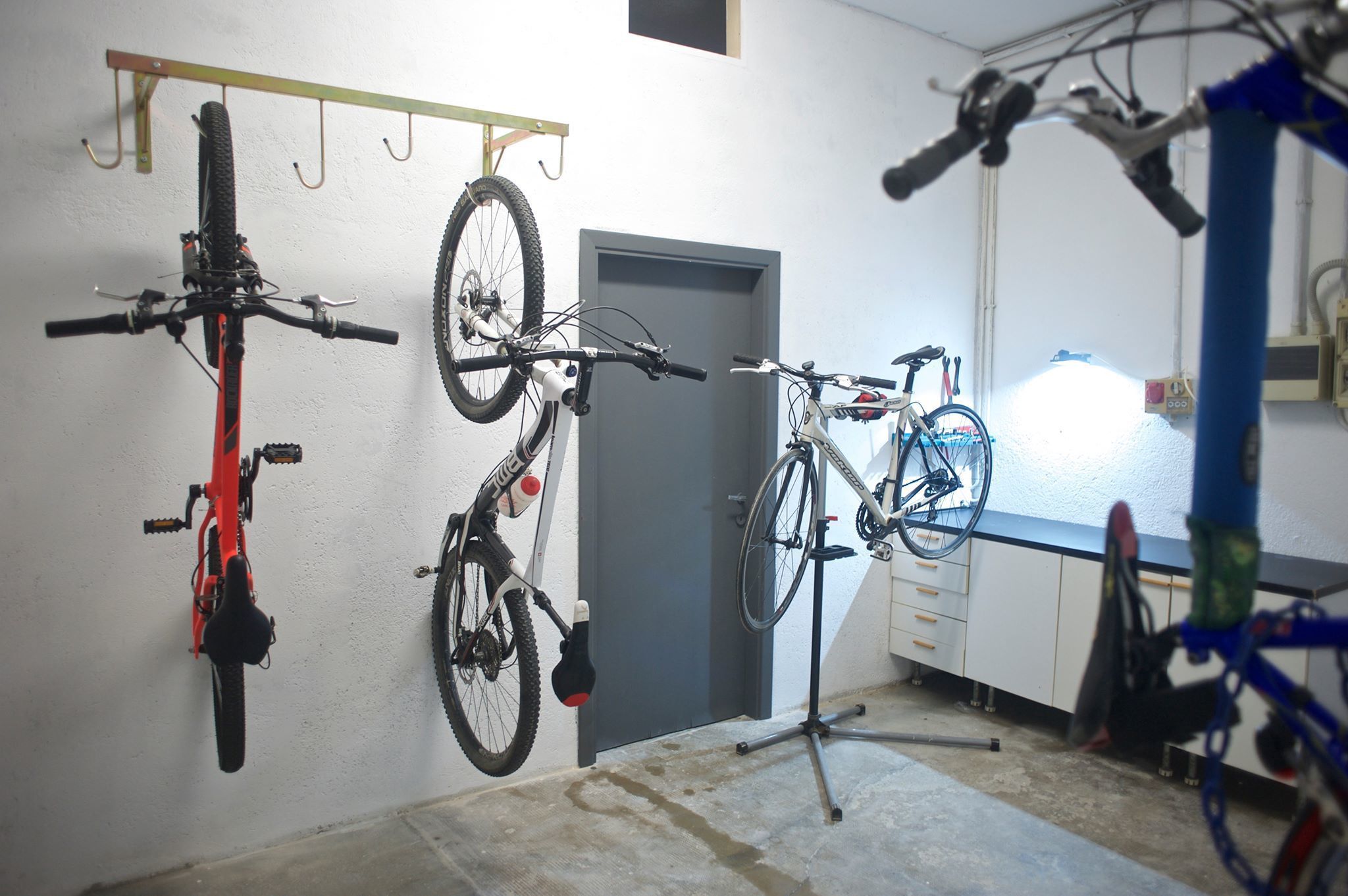 A room with bicycles mounted on a wall and a door.