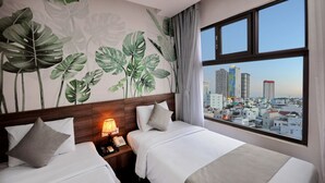 A hotel room with two beds, a city view, and a wall mural of tropical leaves. - Mega Light Hotel (Bac Nha Trang)